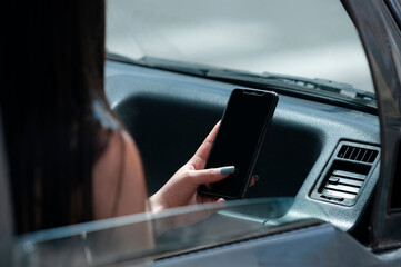 detail of a woman using her cell phone sitting in a car