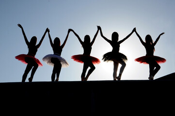 Silhouette of a group of young ballerinas dancing.