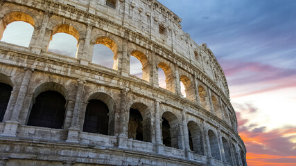 Fototapeta premium The ancient monument, the Roman Colosseum as the sun sets near the forum in Rome, Italy.