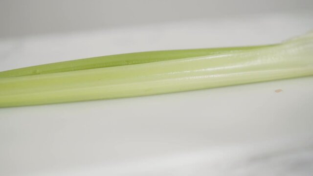 Curring vegetables on a white cutting board to cook vegetarian white bean soup.