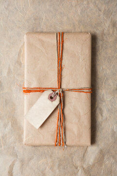 Christmas present tied with orange and beige rope