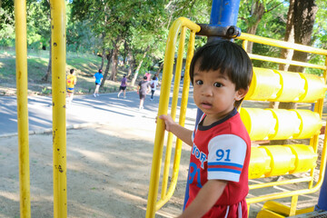 Fototapeta na wymiar Little boy enjoying colorful playground park with slider