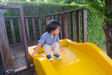 Fototapeta na wymiar Little boy enjoying colorful playground park with slider