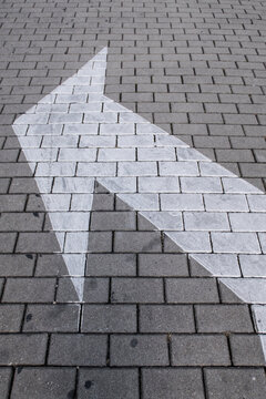Arrow on pavement pointing to left side