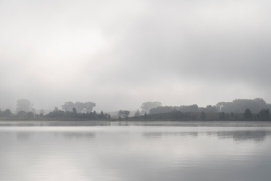Mist rises from a lake in the morning; Masuria/ Poland