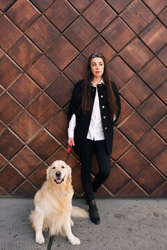 Full length of beautiful brunette with a white dog.