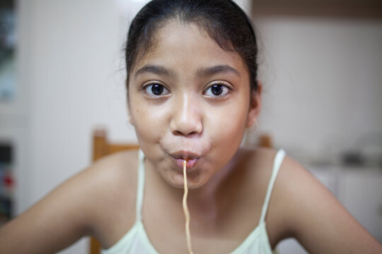 Teenage girl eating noodle and making fun