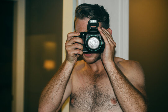 Shirtless Man With Hairy Chest Taking Picture On Camera With Pop