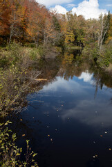 Reflections in a river and colorful trees in autumn