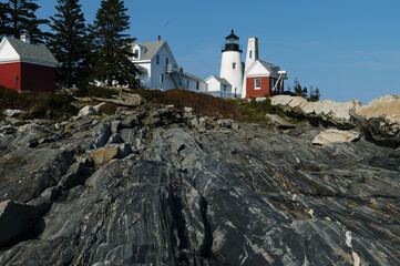 Fototapeta na wymiar Maine Lighthouse Sits Above Unique Rock Formations