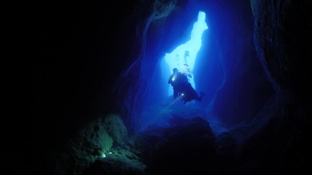 cave diving underwater scuba divers exploring caves ocean scenery 