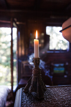 burning old candle vintage bronze candlestick on wooden background