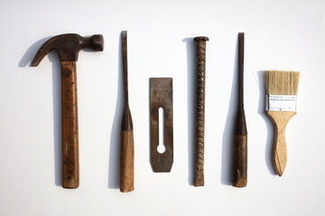 Hammer, wrench, brush and other tools on the white background board