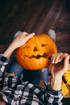 Close up shot of woman decorating halloween pumpkin.
