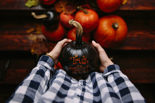 View from above of girl holding pumpkin