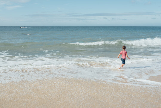 boy running by the waves