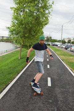 Caucasian man freestyling with his longboard on an asphalted tra