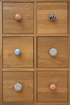 Set os square drawer units with different coloured handles.