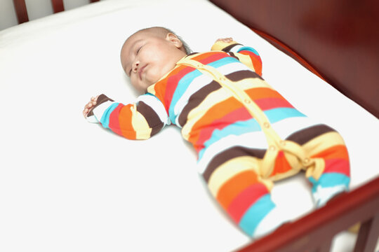 asian baby sleeping on the baby cot