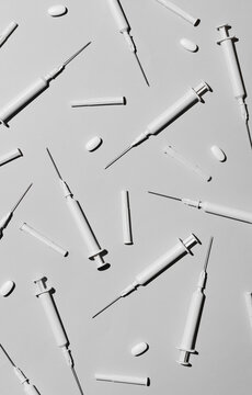 Blanc hypodermic needles adn pills on white background.