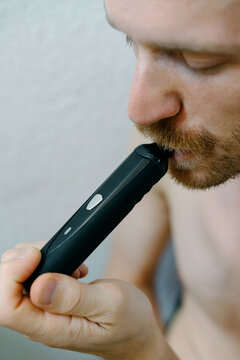 Young man with electronic cigarette in his hand