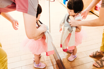 mother and baby girl choosing dress