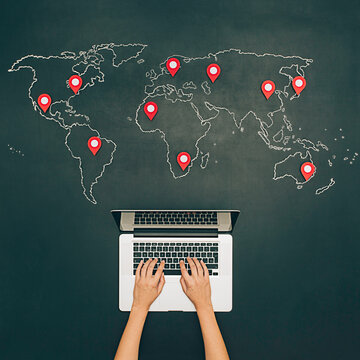 Internet search with notebook. World map on chalkboard with pins.