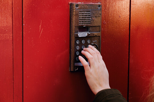 Woman calling on the intercom and presses the button