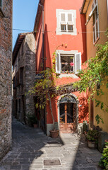Narrow street Via Tavarnelli in Montecatini Alto, Tuscany, Italy, with the street name on the plate