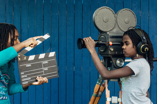 Two black girls filming with a vintage 16mm camera