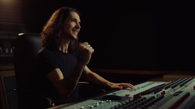 Joyful man gesticulating in music studio. Happy guy listening to music indoor.