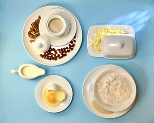 Ingredients for yeast fermented dough. In white porcelain utensils the layout on a blue background.