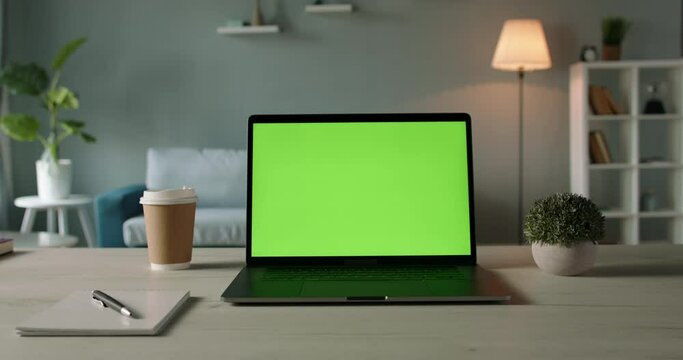 Copy space template - close up shot of modern laptop with chroma key green set up for work in living room at home - technology, design concept 4k zoom shot