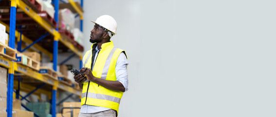 middle aged African American warehouse worker preparing a shipment in large warehouse distribution centre