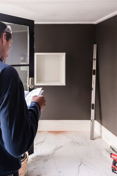 home renovation, a man reading instructions for diy furniture