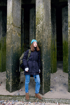 Lady among square mossed columns.