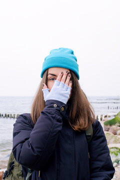 Stylish girl hiding one eye to hand.