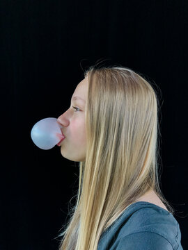 Teenage girl blowing bubble gum bubble