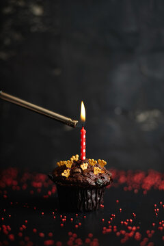 Chocolate cake with a single candle and gold crowns.