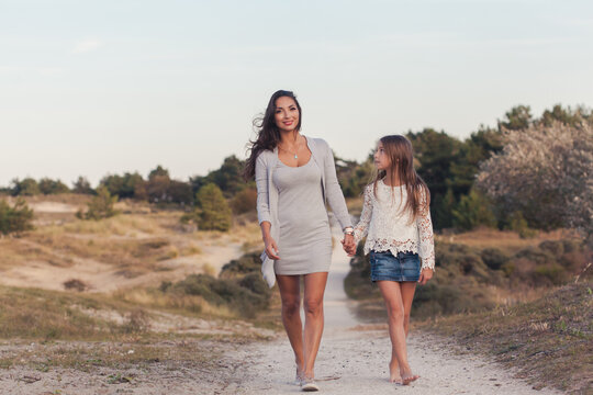 Mother and daughter walking on a path in the dunes