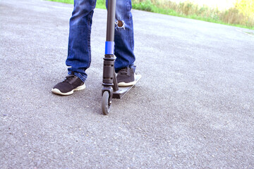 Close-up - feet of a boy on a scooter. Active rest, healthy lifestyle