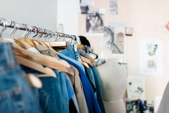 vintage clothing pieces hung on rack in diy fashion studio workshop space