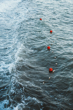 Line of red signal buoys floating in the sea