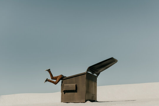 Garbage in, Garbage Out Idiom Concept of human legs flying in the air with his head stuck in the trash
