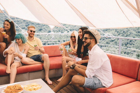 Group of friends drinking cocktails and having fun outdoors