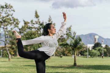 Fototapeta na wymiar Woman doing yoga outdoors at a park