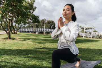 Fototapeta premium Woman doing yoga outdoors at a park
