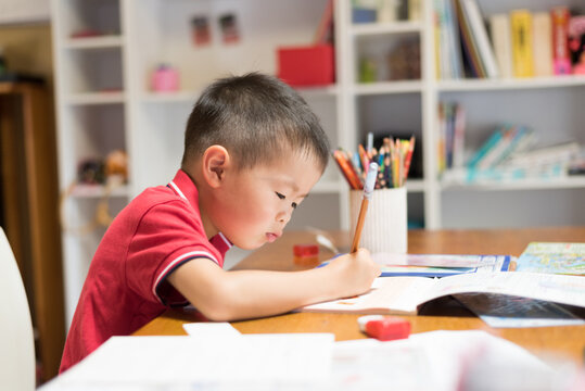 a boy writting on table