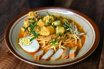 Curry noodle in a plate. Famous food called Mee Kari in malaysia. Noodle in a chicken curry gravy