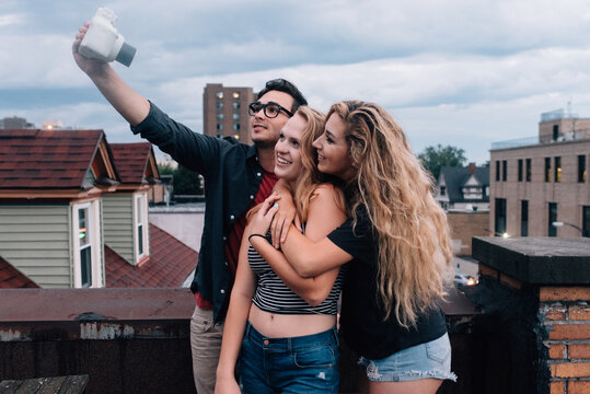 Young friends taking pictures in the city